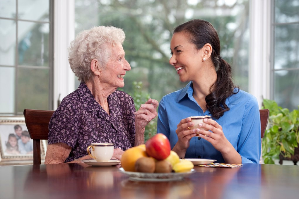 home care aide offers joyful companionship to elderly woman
