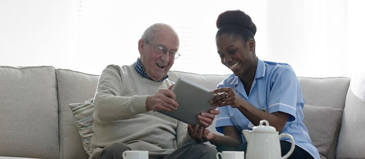 Home health aide shares a laugh with elderly man