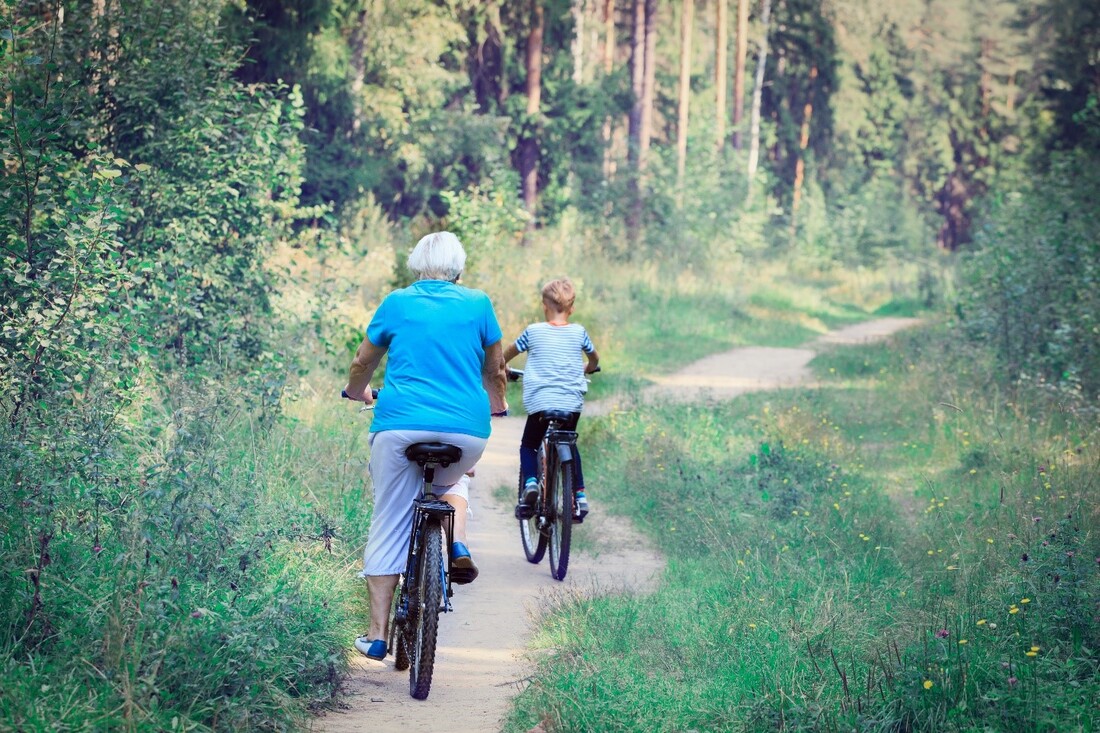 senior woman biking with a young child
